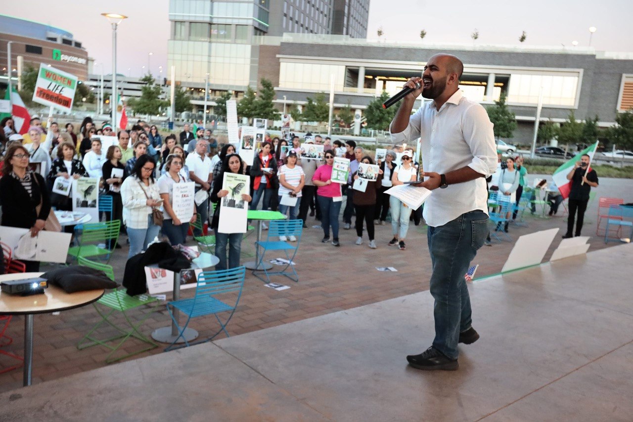 Peyman speaking to a large crowd at an Iran solidarity rally